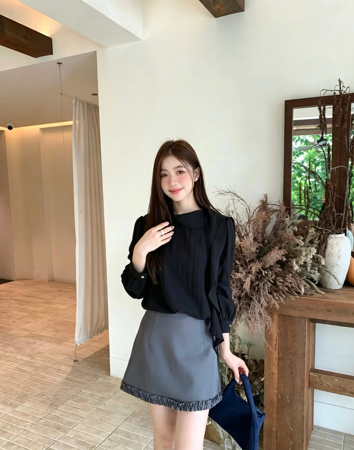 Model wearing a black French design shoulder button tie blouse