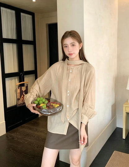 Model wearing a khaki two-way tie blouse and brown skirt.