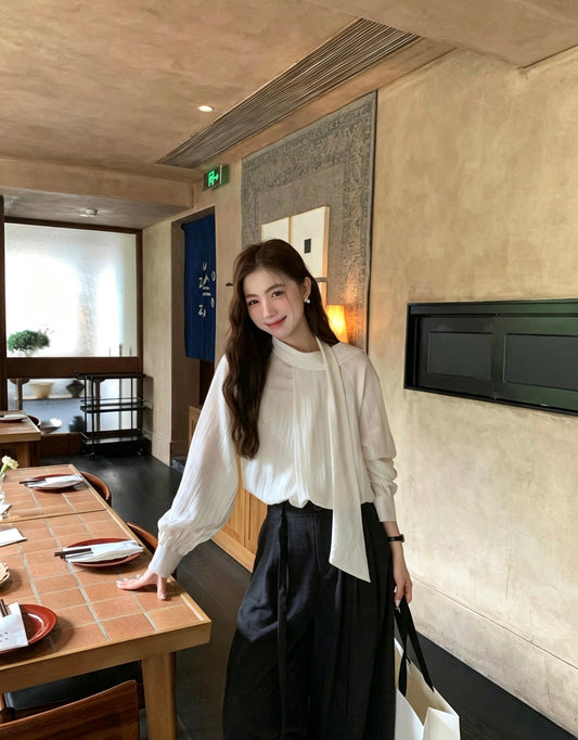 Model wearing an apricot two-way tie blouse in a restaurant setting.