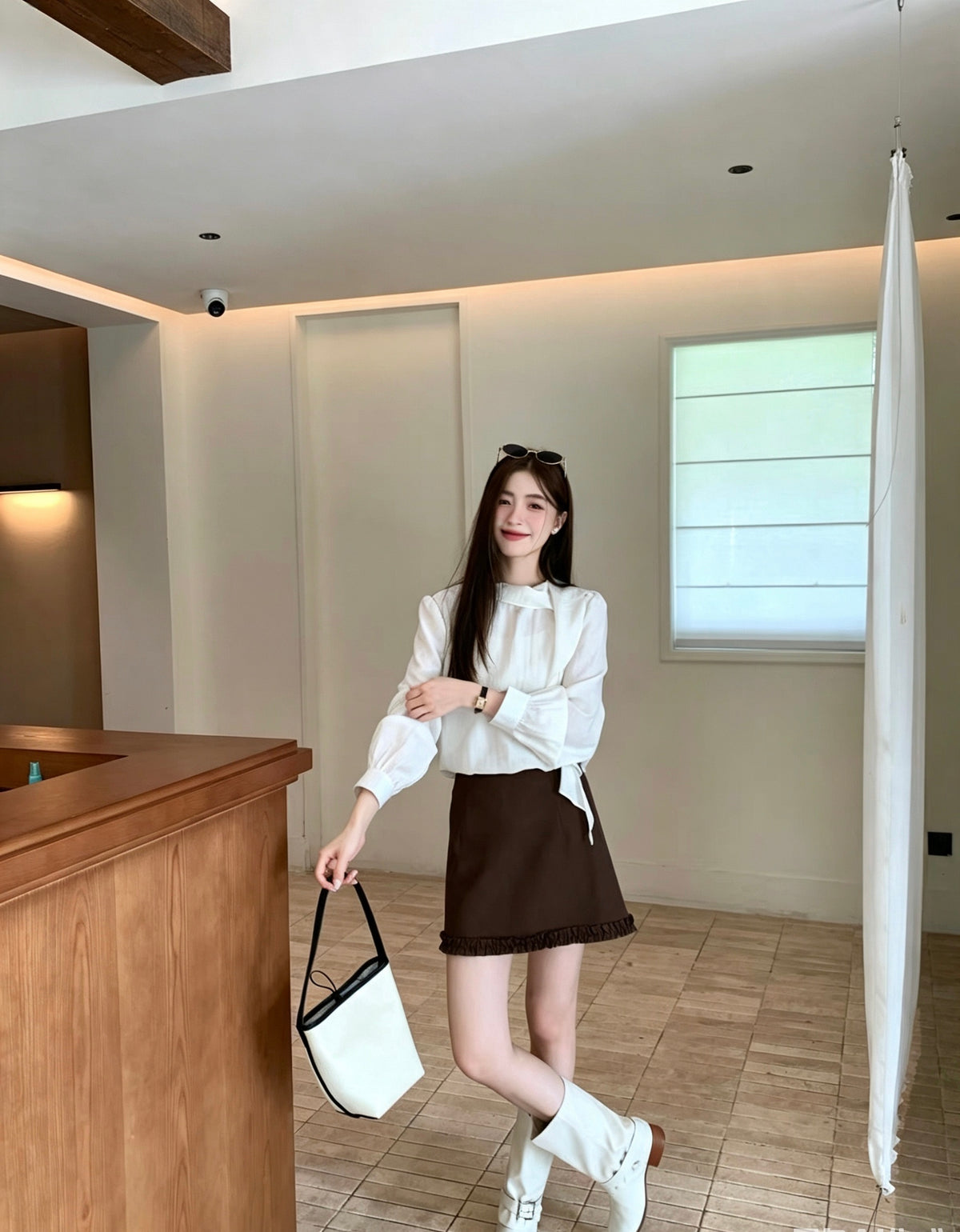 Model posing in a white French design shoulder button tie blouse