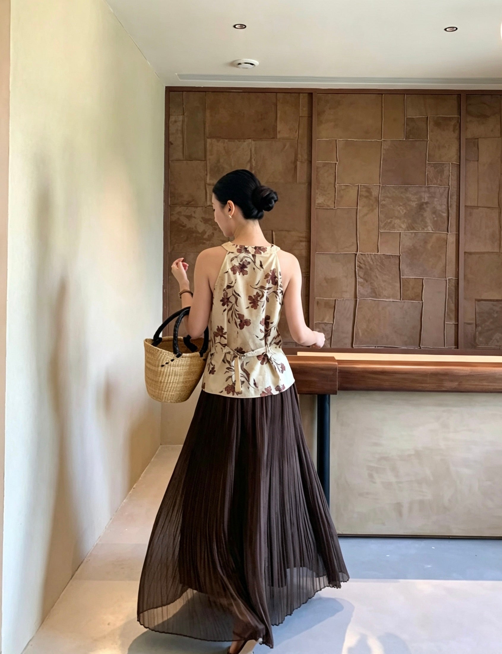 Back view of a model wearing a dark brown pleated maxi skirt