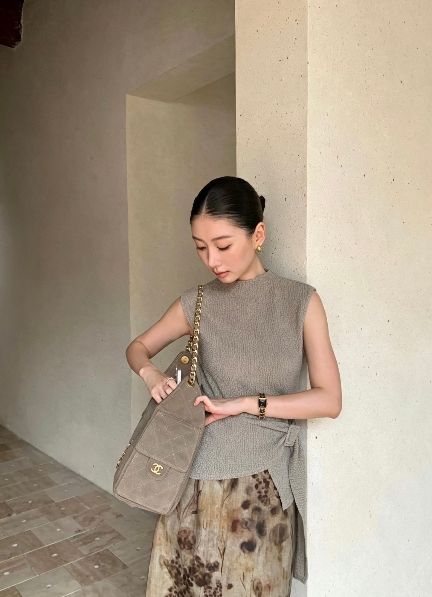 Model in apricot sleeveless top and floral skirt