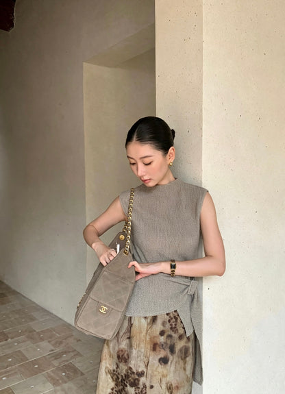 Model in apricot sleeveless top and floral skirt