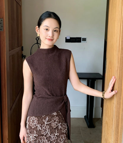 Model wearing coffee sleeveless top and lace skirt