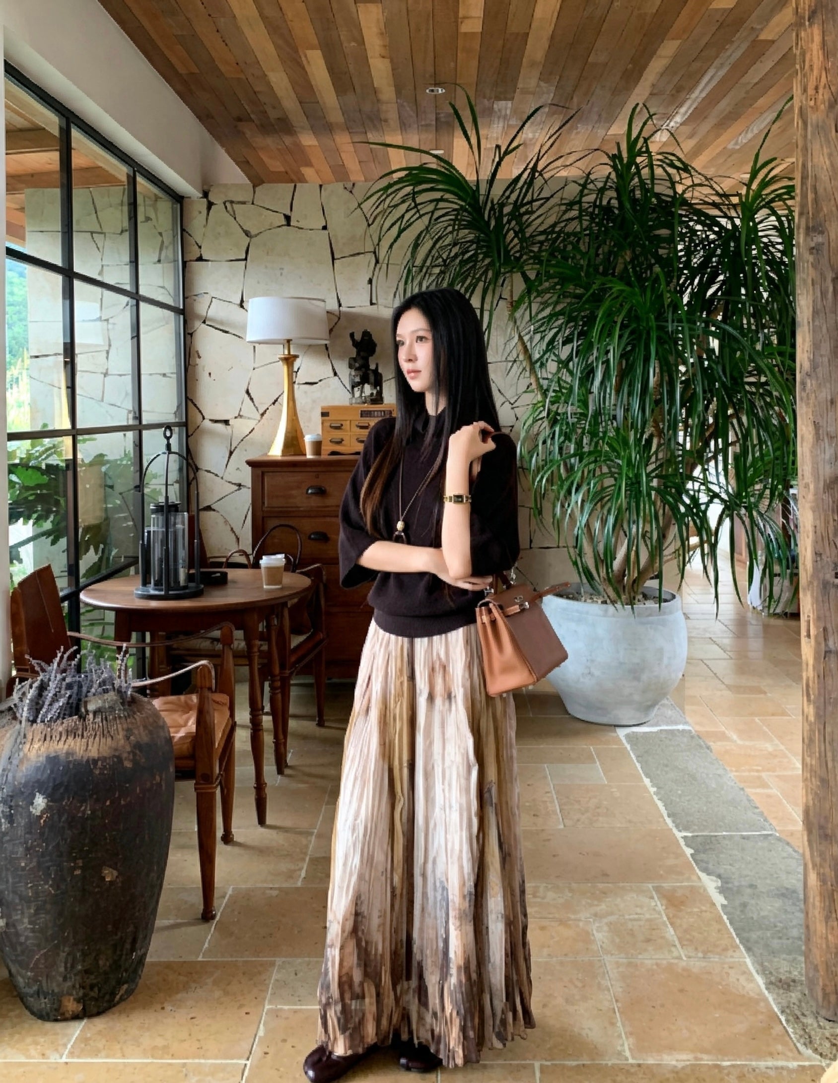 Elegant woman wearing a khaki tie-dye pleated skirt indoors
