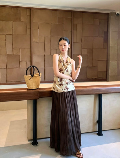 Model wearing a dark brown pleated maxi skirt and floral top