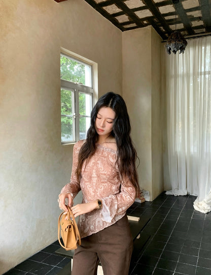 Model looking down wearing retro print off-shoulder top