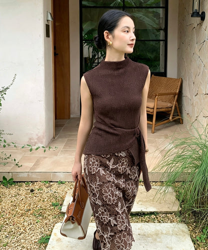Model in coffee textured top carrying a bag