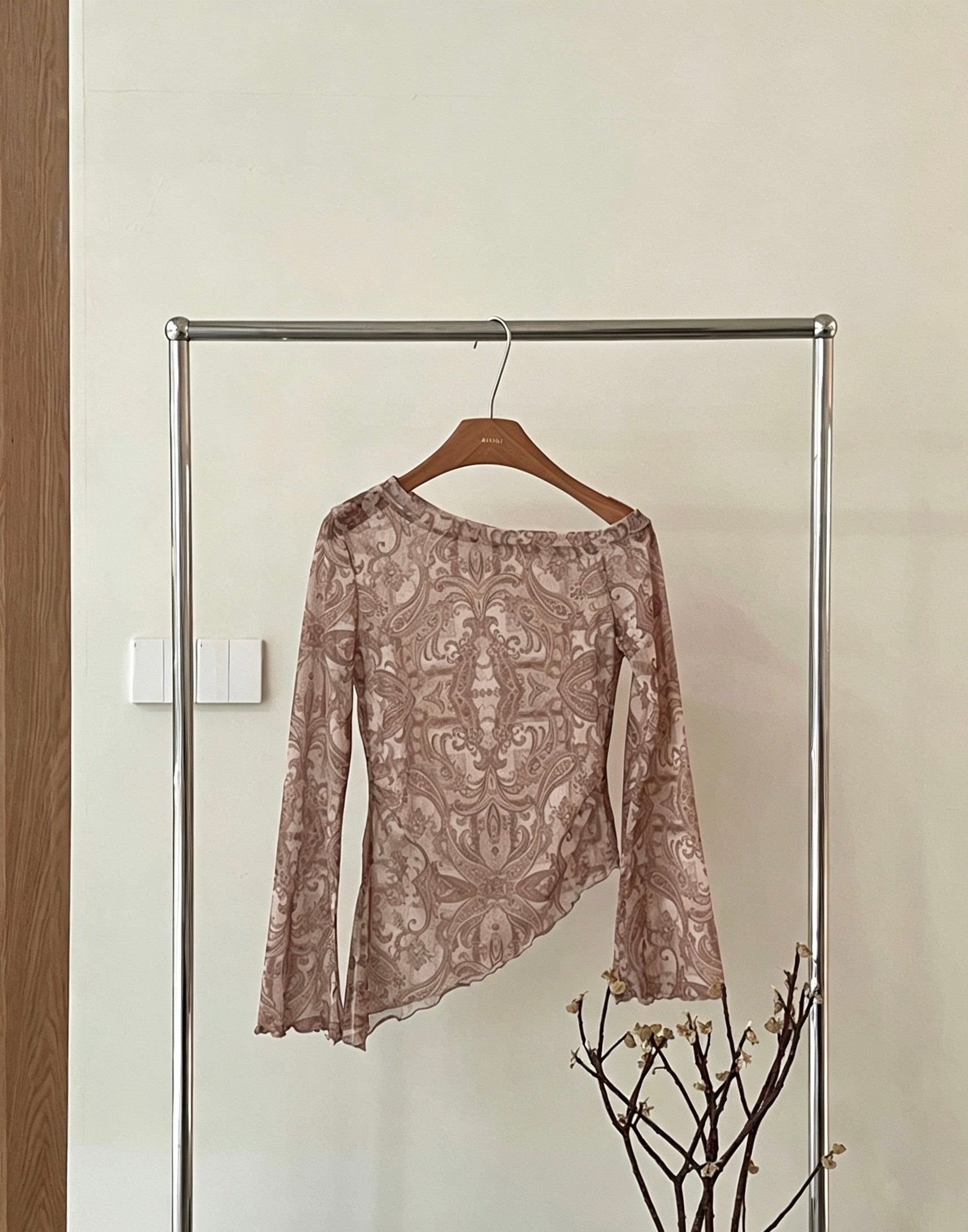 Brown retro print asymmetrical off-shoulder shirt on clothing rack