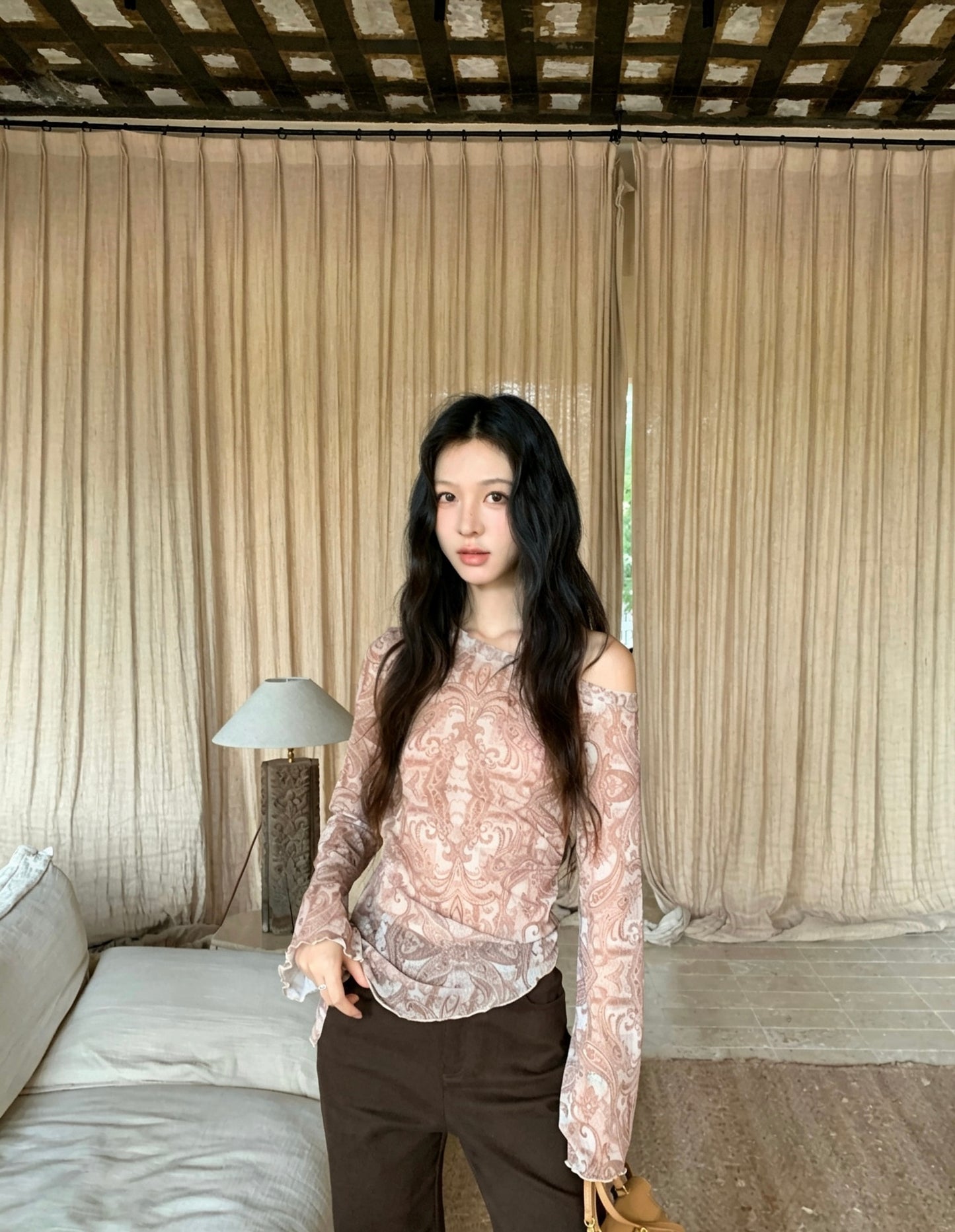 Model in brown off-shoulder sheer long sleeve top