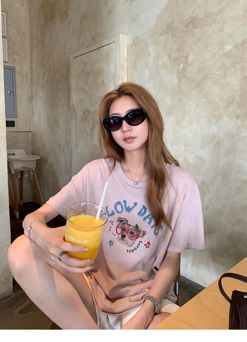 Woman sitting down wearing a purple cute dog graffiti t-shirt