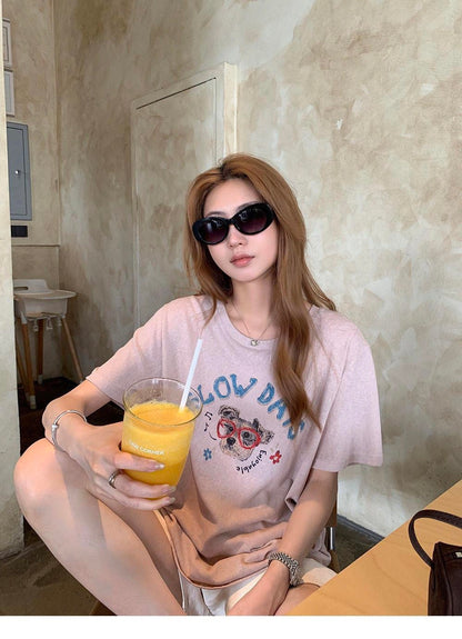Woman sitting down wearing a purple cute dog graffiti t-shirt