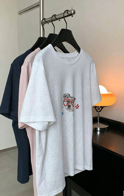 Navy, purple, and white dog graffiti t-shirts hanging on a rack