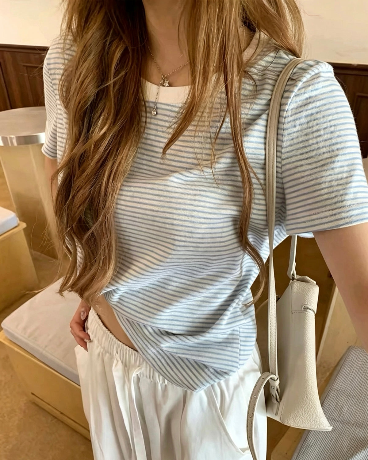 Model wearing a refreshing light blue striped short-sleeve t-shirt with white pants