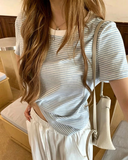 Model wearing a refreshing light blue striped short-sleeve t-shirt with white pants