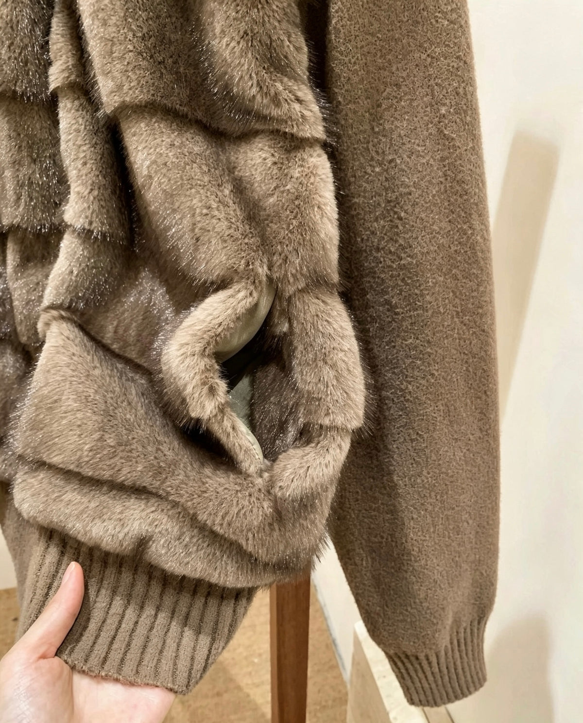 Close-up of brown faux fur jacket pocket and knit hem