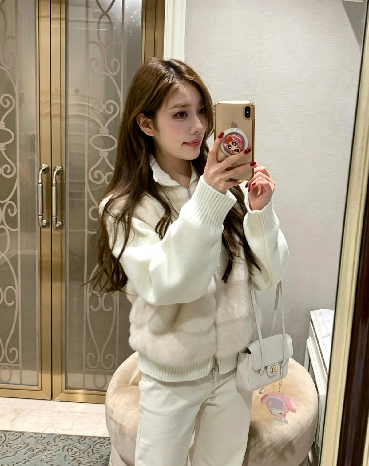 Woman taking mirror selfie in apricot faux fur knit jacket