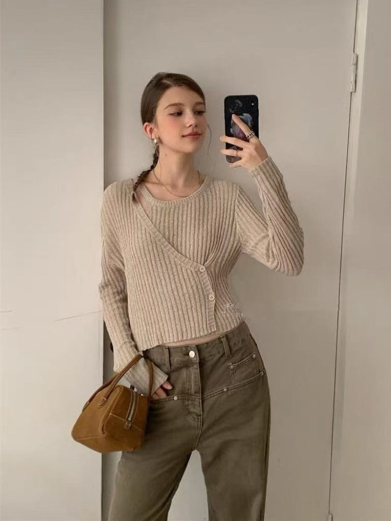 Model taking a mirror selfie in a beige ribbed knit top