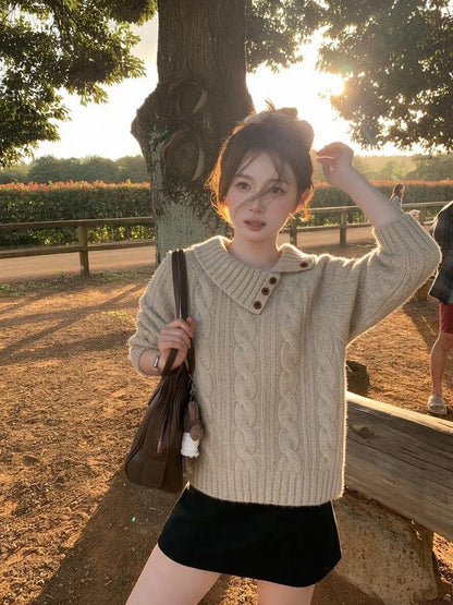 Woman wearing khaki asymmetrical button cable knit sweater