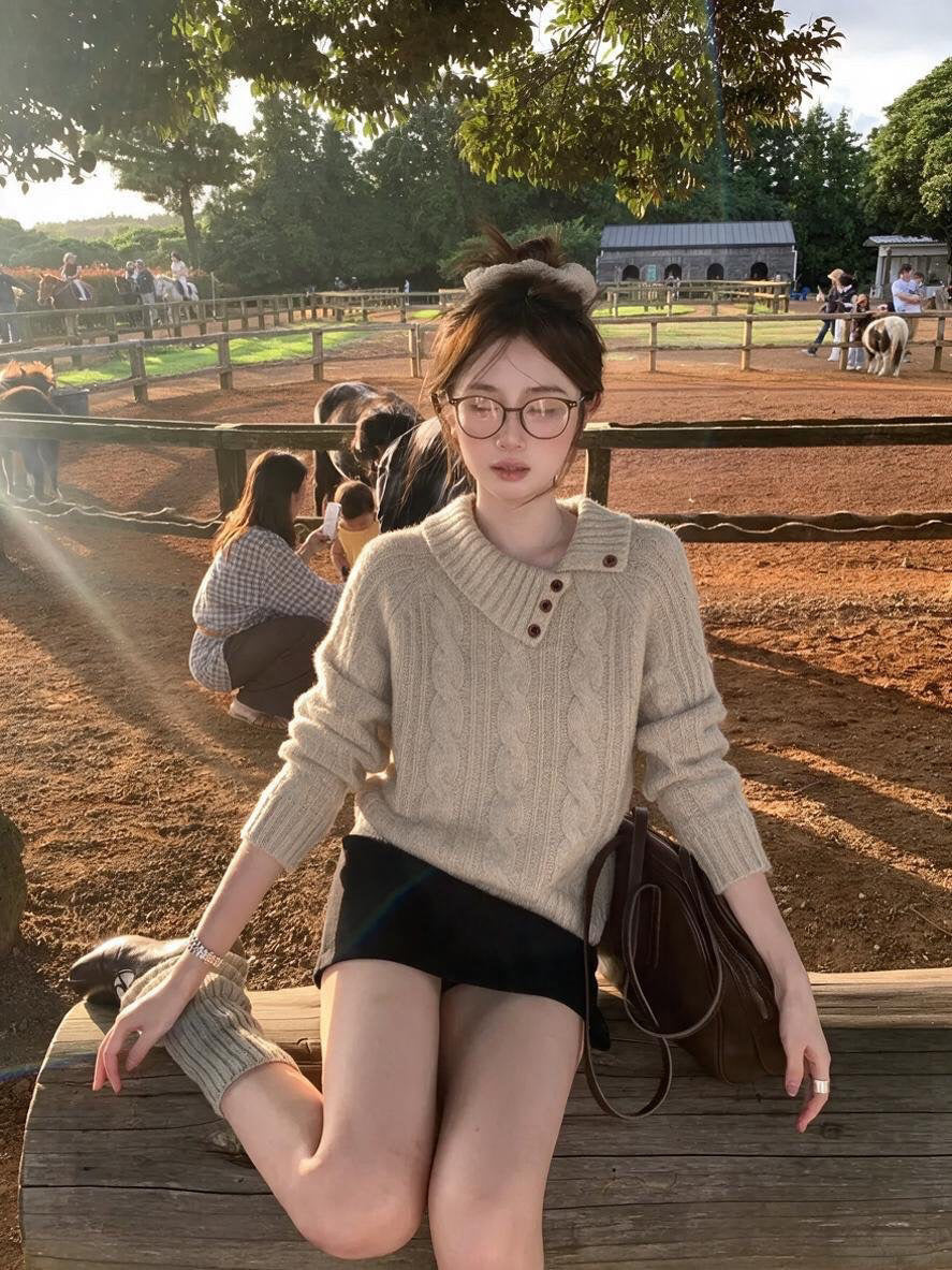 Woman wearing khaki asymmetrical button cable knit sweater