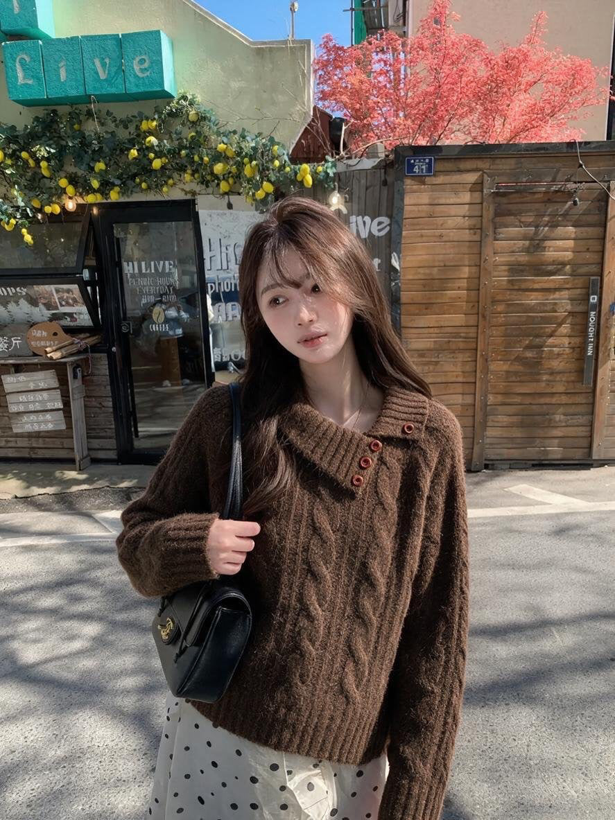 Woman wearing orange asymmetrical button cable knit sweater