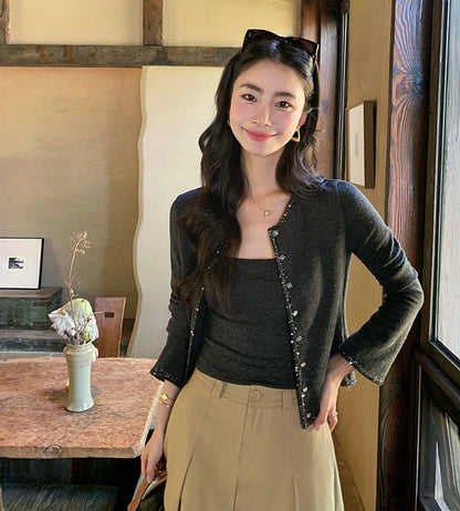 Model posing in a dark grey camisole and cardigan two-piece set