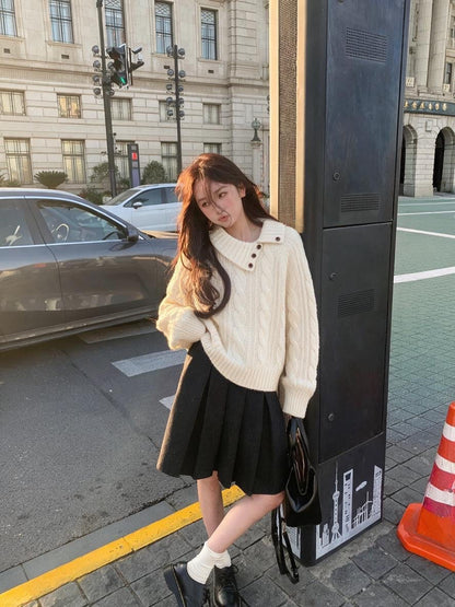 Woman wearing beige asymmetrical button cable knit sweater