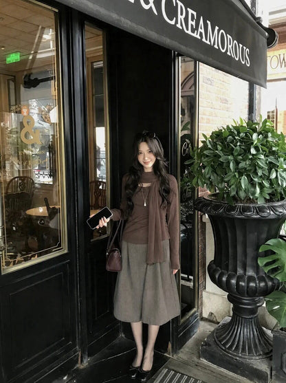 Model in brown top standing outside cafe