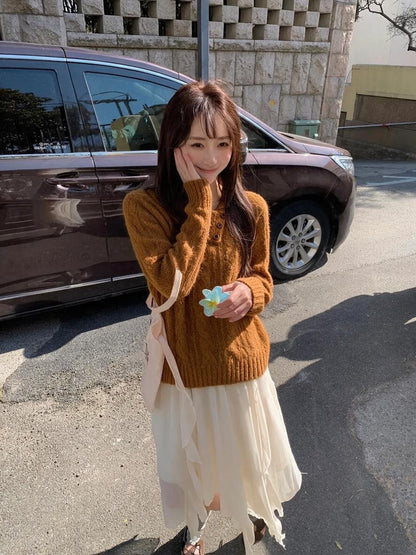 Woman wearing orange asymmetrical button cable knit sweater