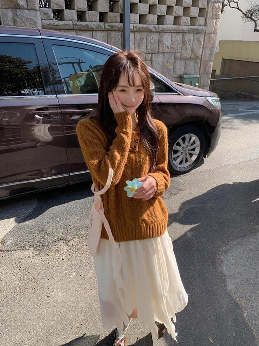 Woman wearing orange asymmetrical button cable knit sweater