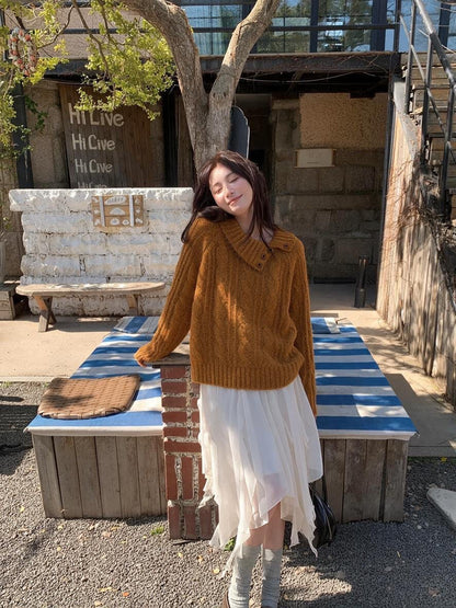 Woman wearing orange asymmetrical button cable knit sweater