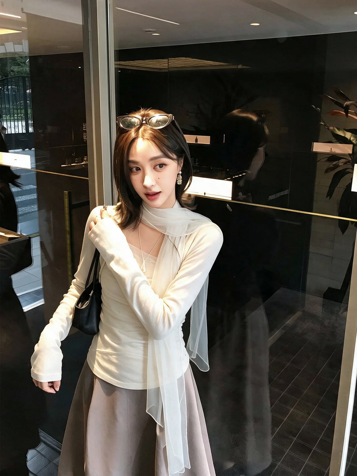 Model wearing white mesh scarf top