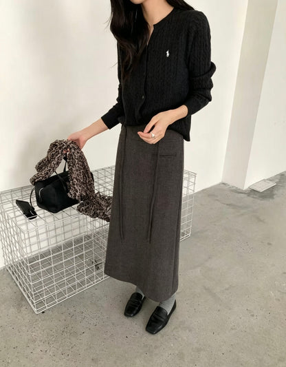 Model wearing a dark grey Korean retro draped high-waisted A-line skirt holding a black bag