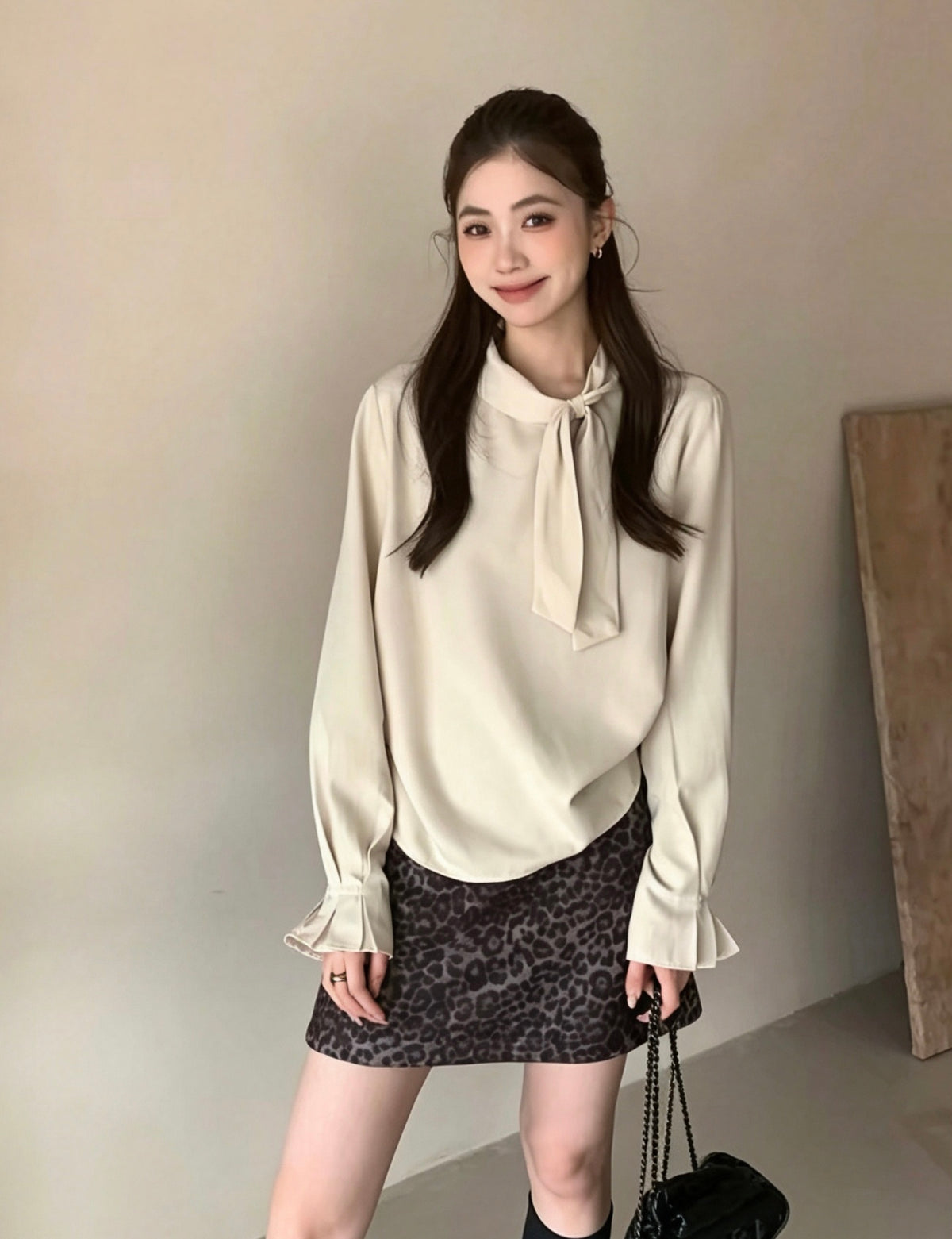 Model wearing apricot tie-neck long-sleeve shirt